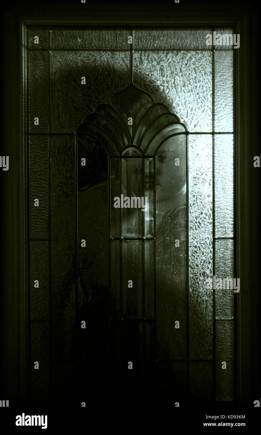 Young Man Looking Through A Glass Door At Night Stock Photo Young Man Looking Through A Glass Door At Night