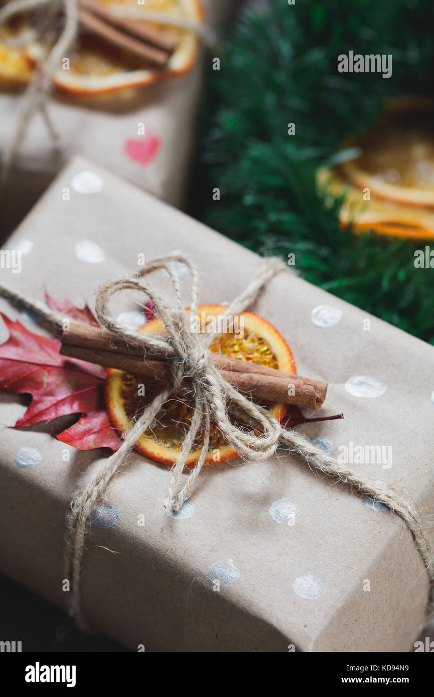 View of christmas gift boxes in a kraft paper decorated dried orange ...