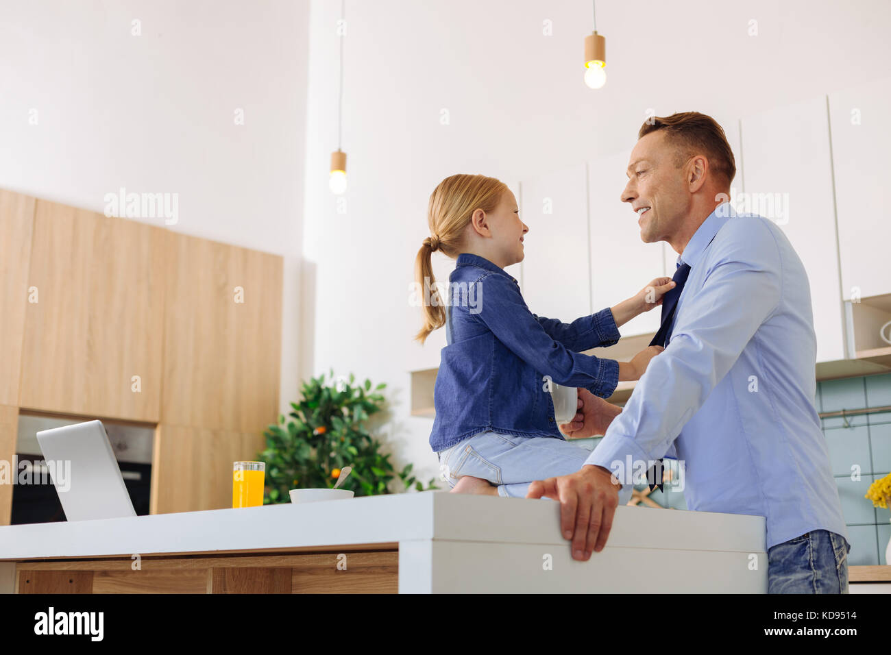 Positive nice girl sitting in front of her father Stock Photo - Alamy