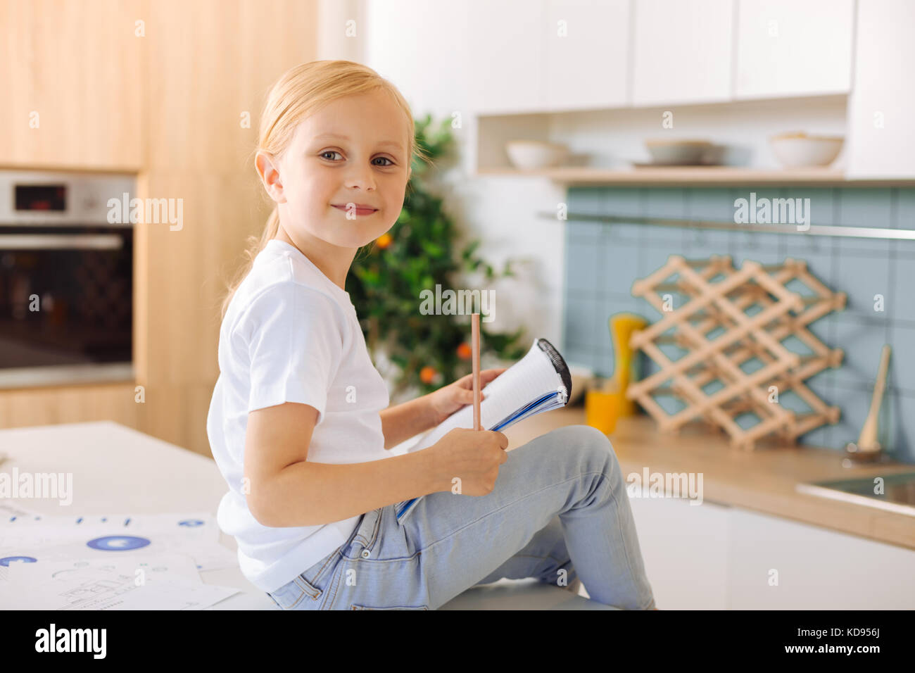 Cheerful nice girl holding a pencil Stock Photo - Alamy