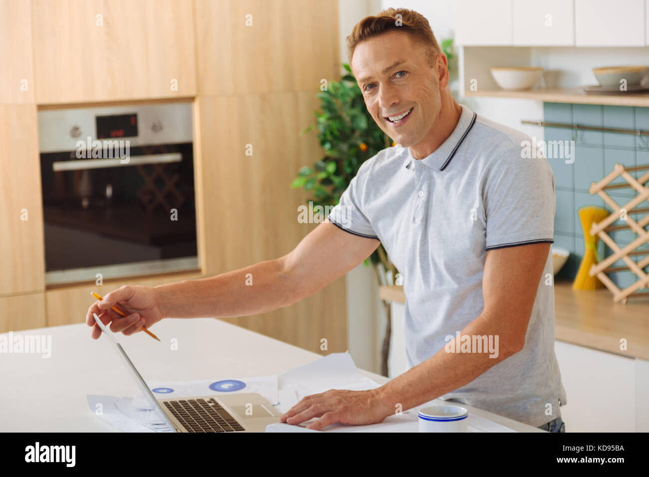 Cheerful positive man opening his laptop Stock Photo