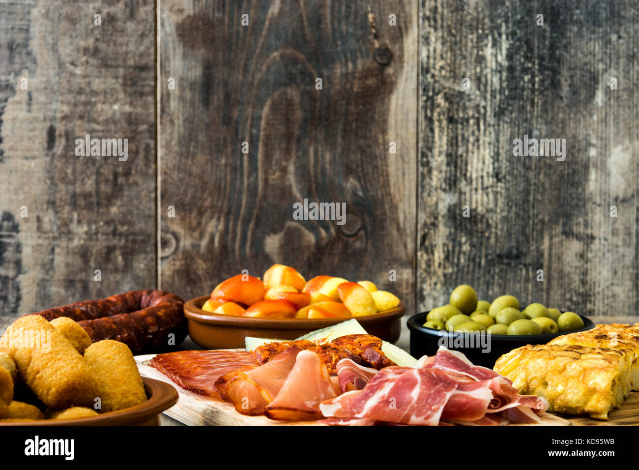 Traditional spanish tapas. Croquettes, olives, omelette, ham and patatas bravas on wooden table Stock Photo