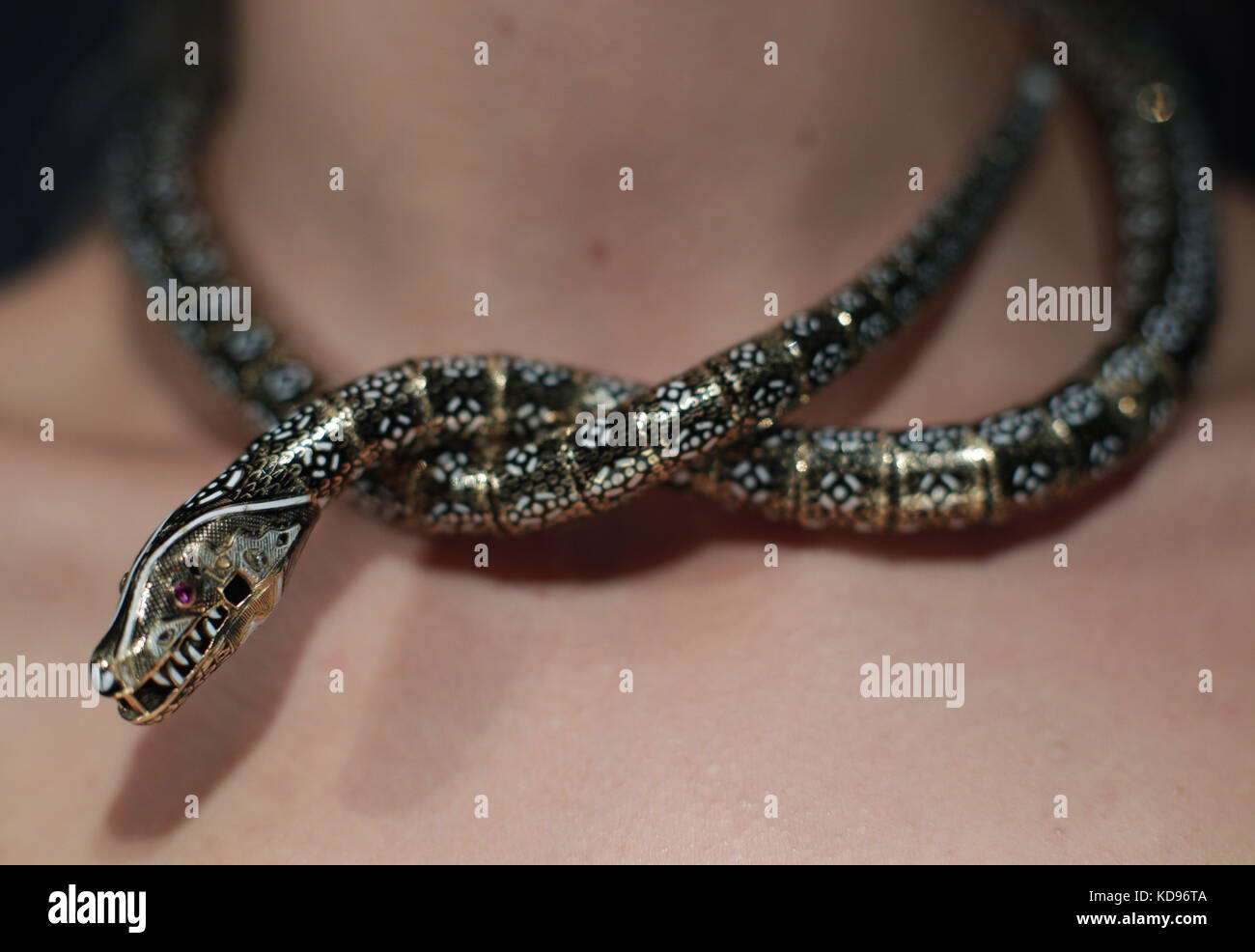 A Sotheby's staff member wearing a mid 19th century enamel and ruby necklace - modelled as a snake, and estimated at £60,000-80,000 - during a press preview for the forthcoming SJ Phillips: a Bond Street Legacy sale at Sotheby's, London. Stock Photo