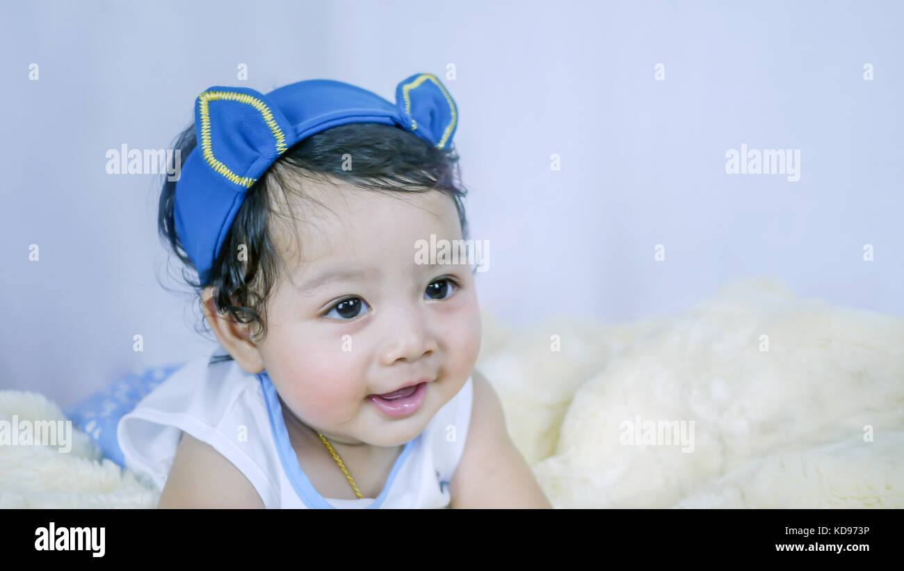 Asian Smiling baby girl crawling in bedroom Stock Photo