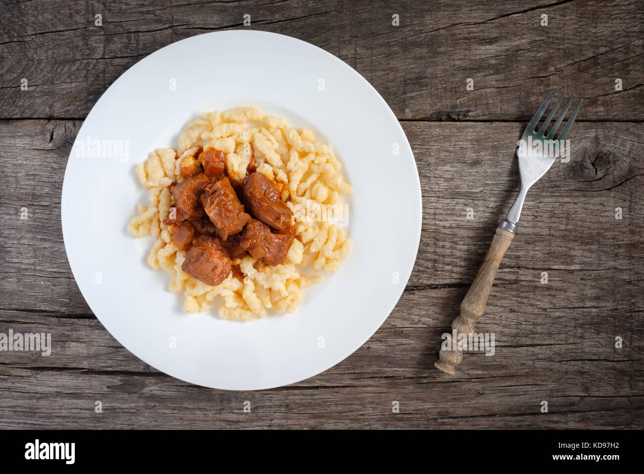 Beef goulash with egg noodles on a plate with fork Stock Photo - Alamy
