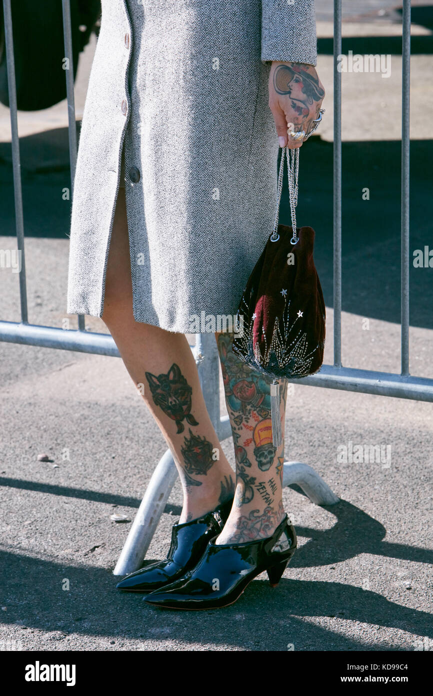 MILAN - SEPTEMBER 20: Woman with black patent leather shoes and tattoed legs before Alberto Zambelli fashion show, Milan Fashion Week street style on  Stock Photo