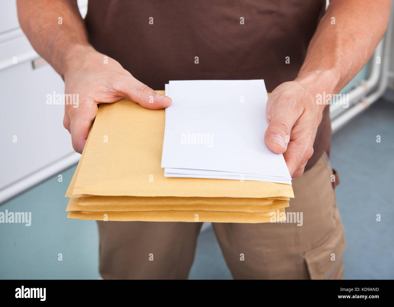 Close-up Photo Of Mature Postman Holding Letters Stock Photo