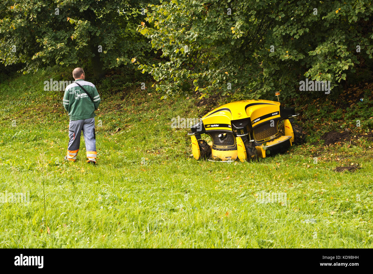 public park maintenance may with robotic lawnmower Stock Photo