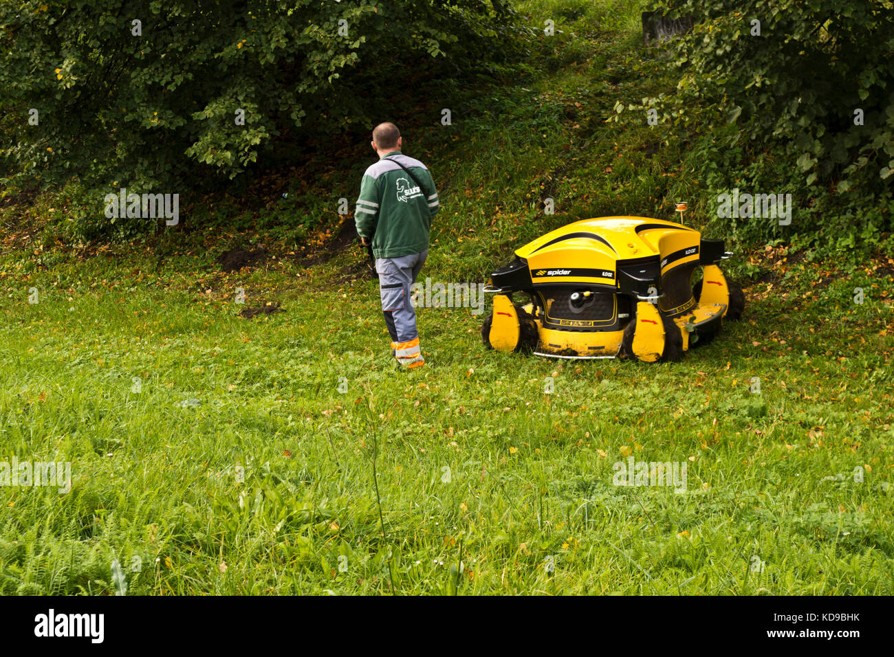 public park maintenance may with robotic lawnmower Stock Photo