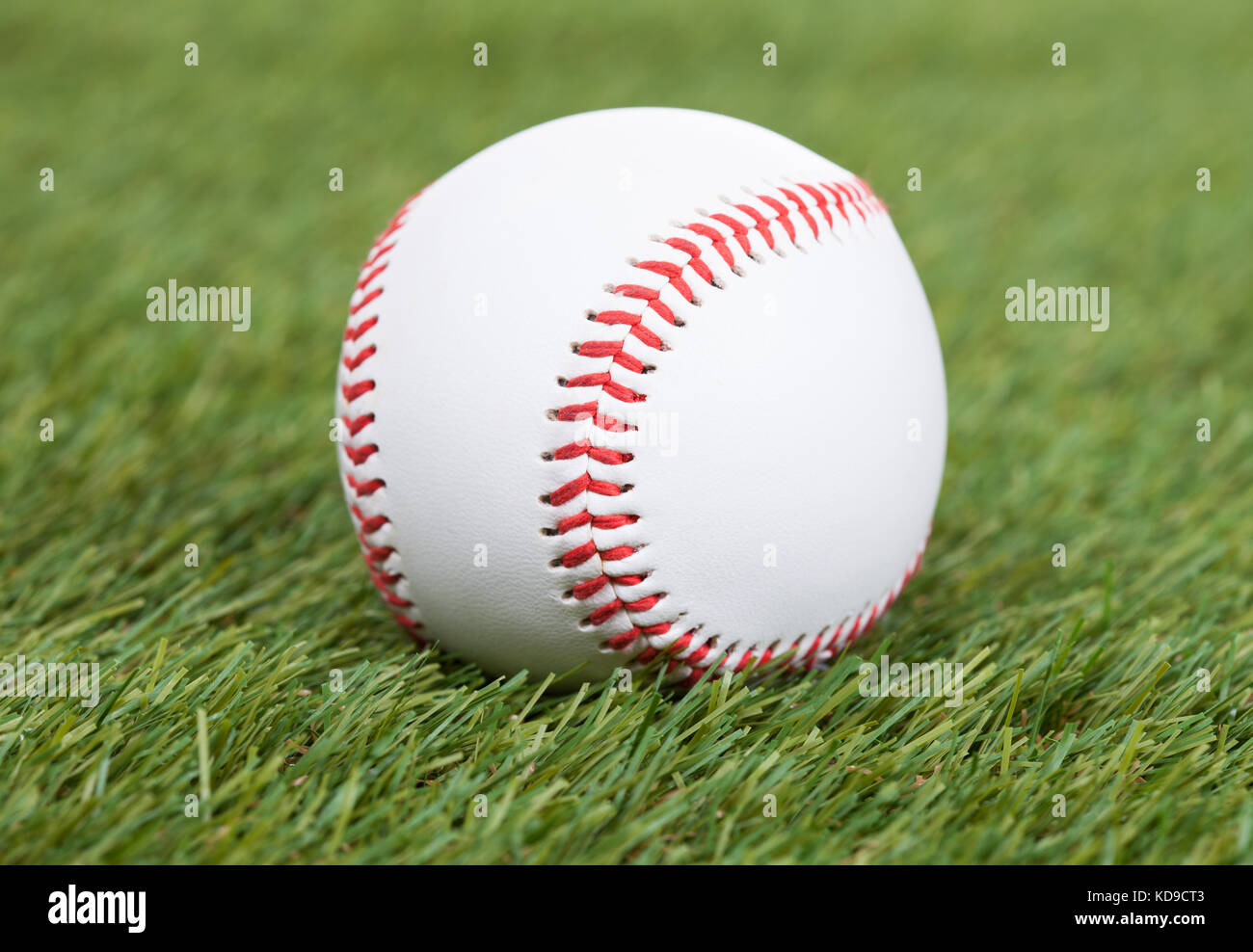 Close-up Of A Baseball On Green Pitch Stock Photo