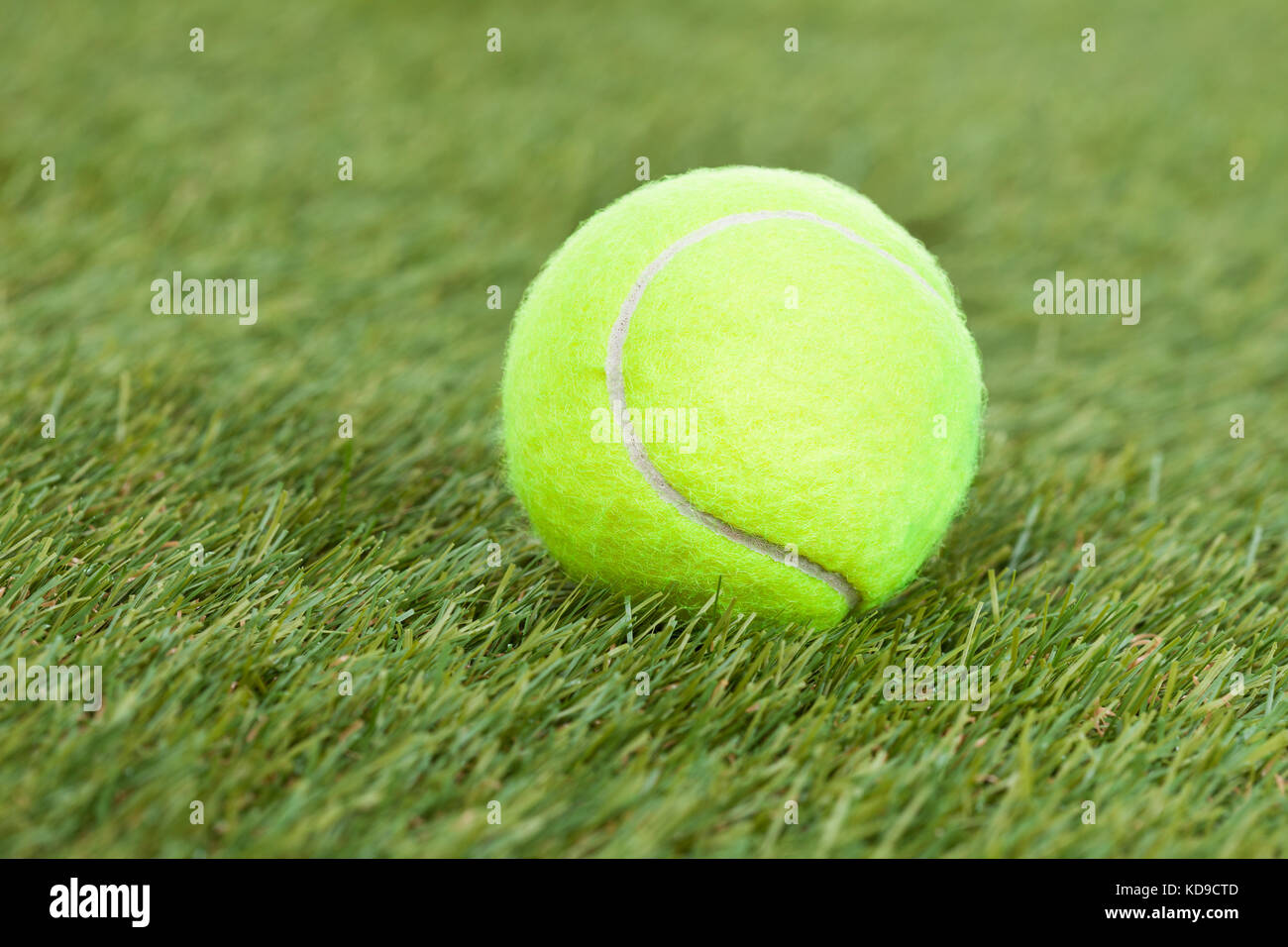 Close-up Of A Tennis Ball On Green Pitch Stock Photo