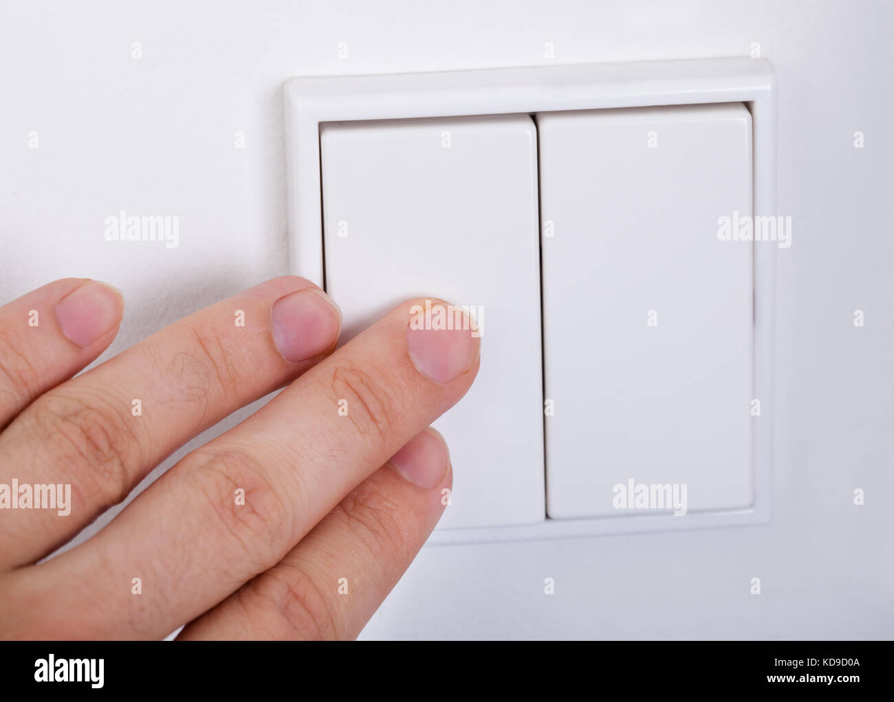 Close-up Of Hand Presses The Light Switch On The Wall Stock Photo