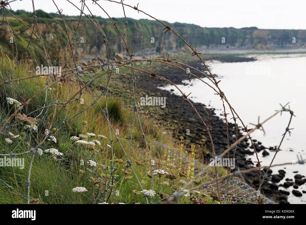 Normandy landings beach - coastline/cliffs with barbed wire Stock Photo