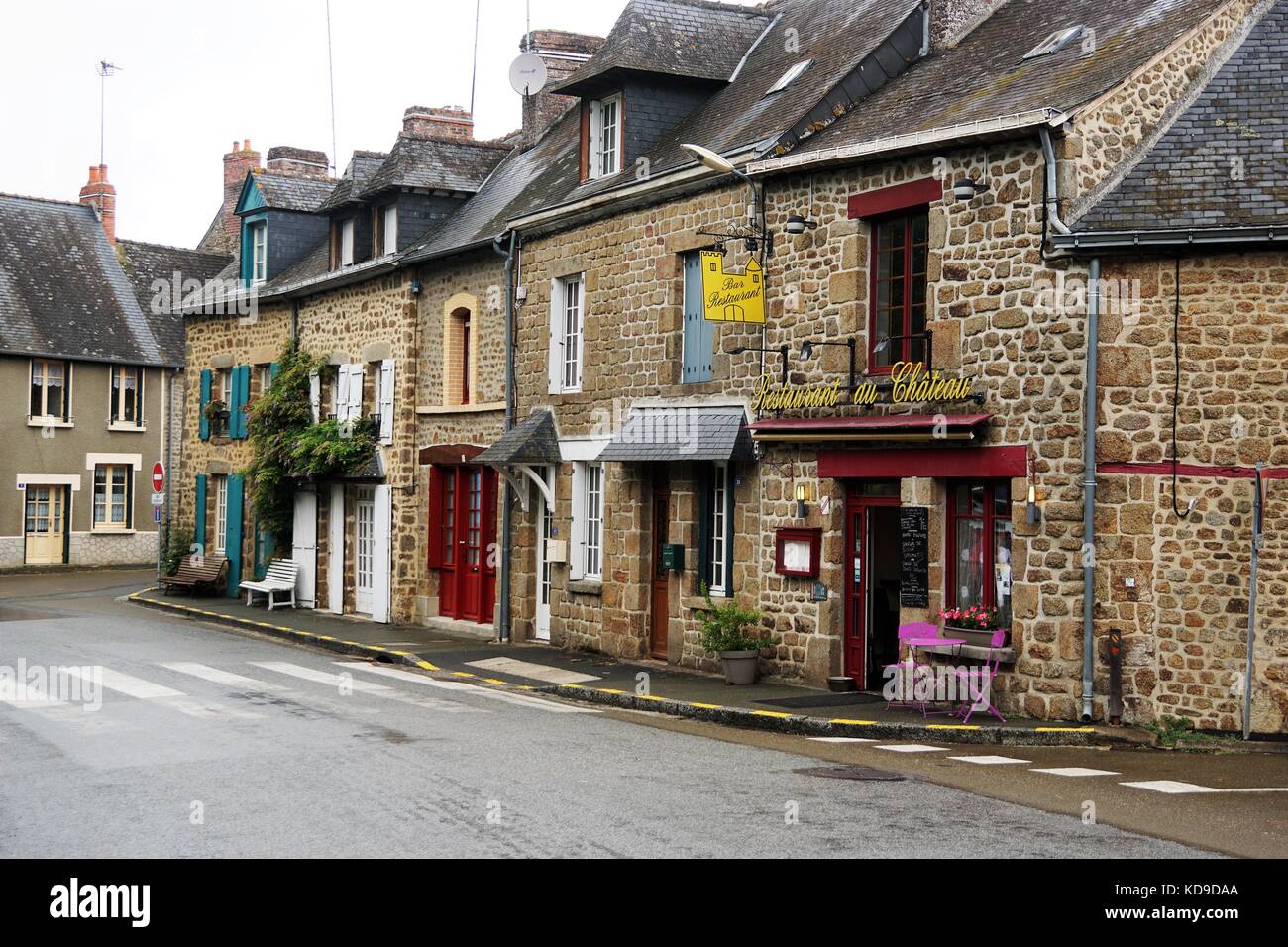 Street With Brick Shops And Buildings Against Grey Sky In Normandy, France Stock Photo