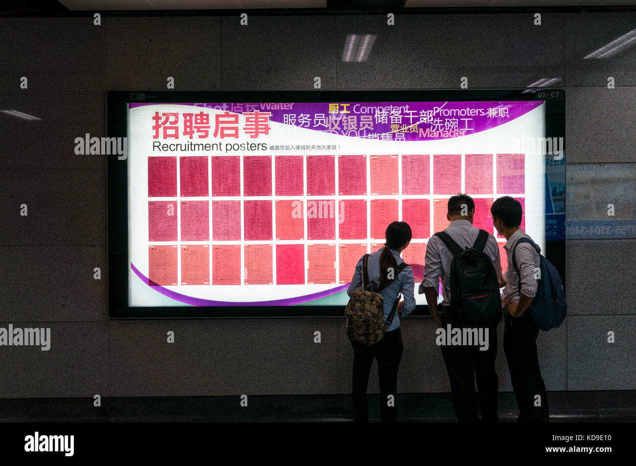 Young professionals in China browse offline job ads near the entrance of a shopping mall in Shenzhen, China Stock Photo