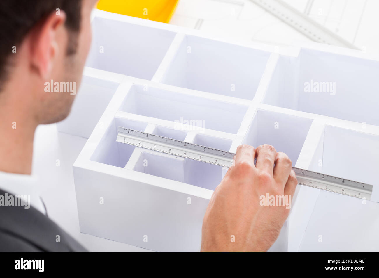 Close-up Of A Male Architect Measuring House Model With Scale Stock Photo