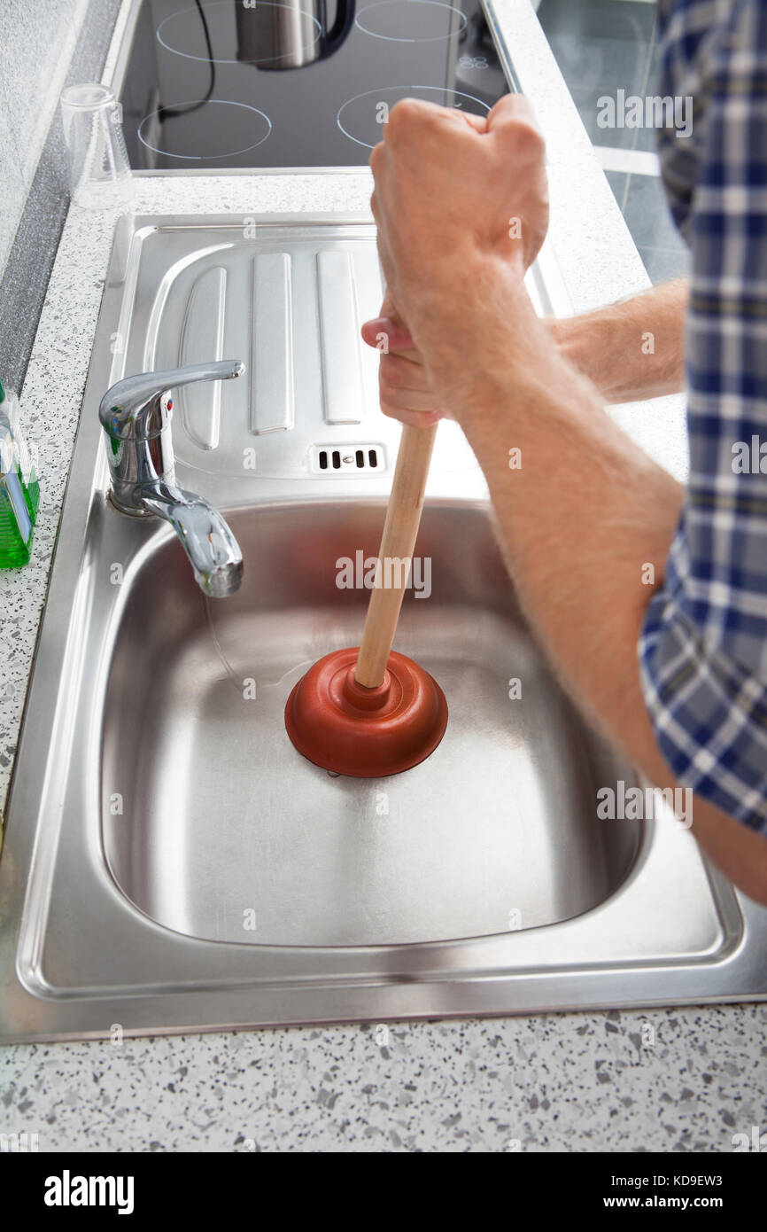 Closeup Of Man Using Plunger In Kitchen Sink Stock Photo Alamy