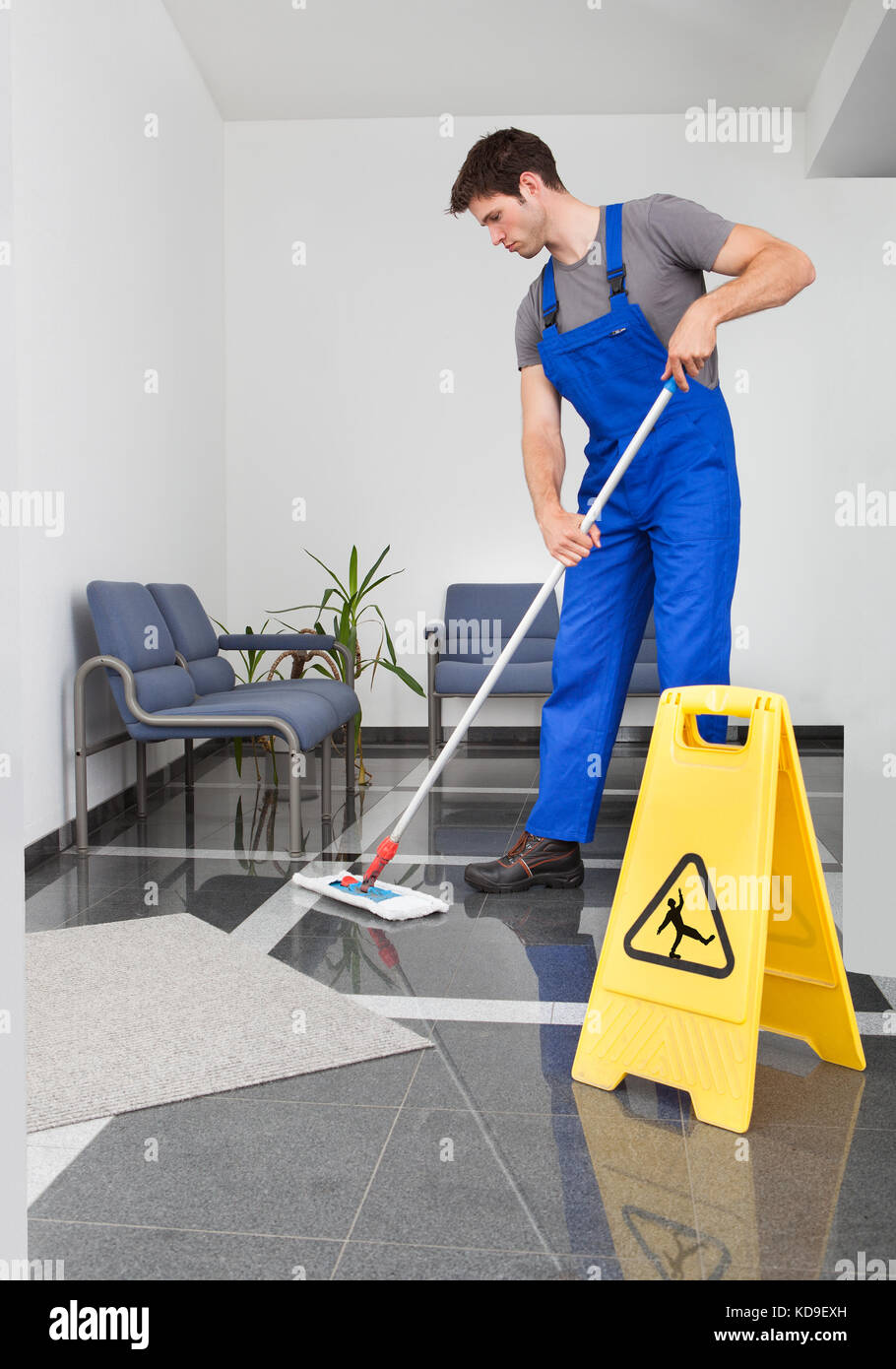 Portrait Of Young Man Cleaning The Floor With Mop In Office Stock Photo -  Alamy