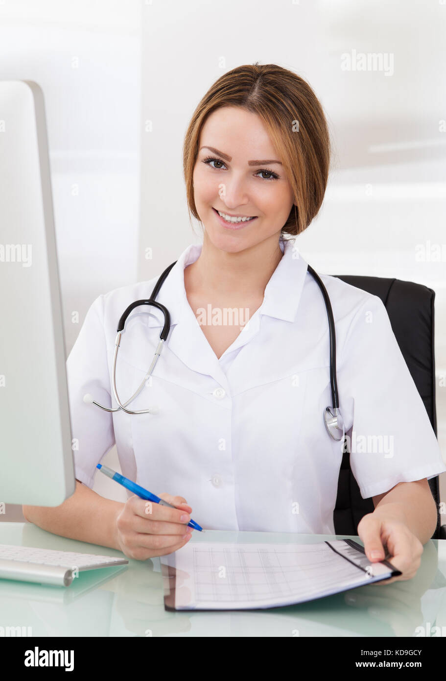 Portrait Of Happy Young Female Doctor Writing Prescription Stock Photo ...