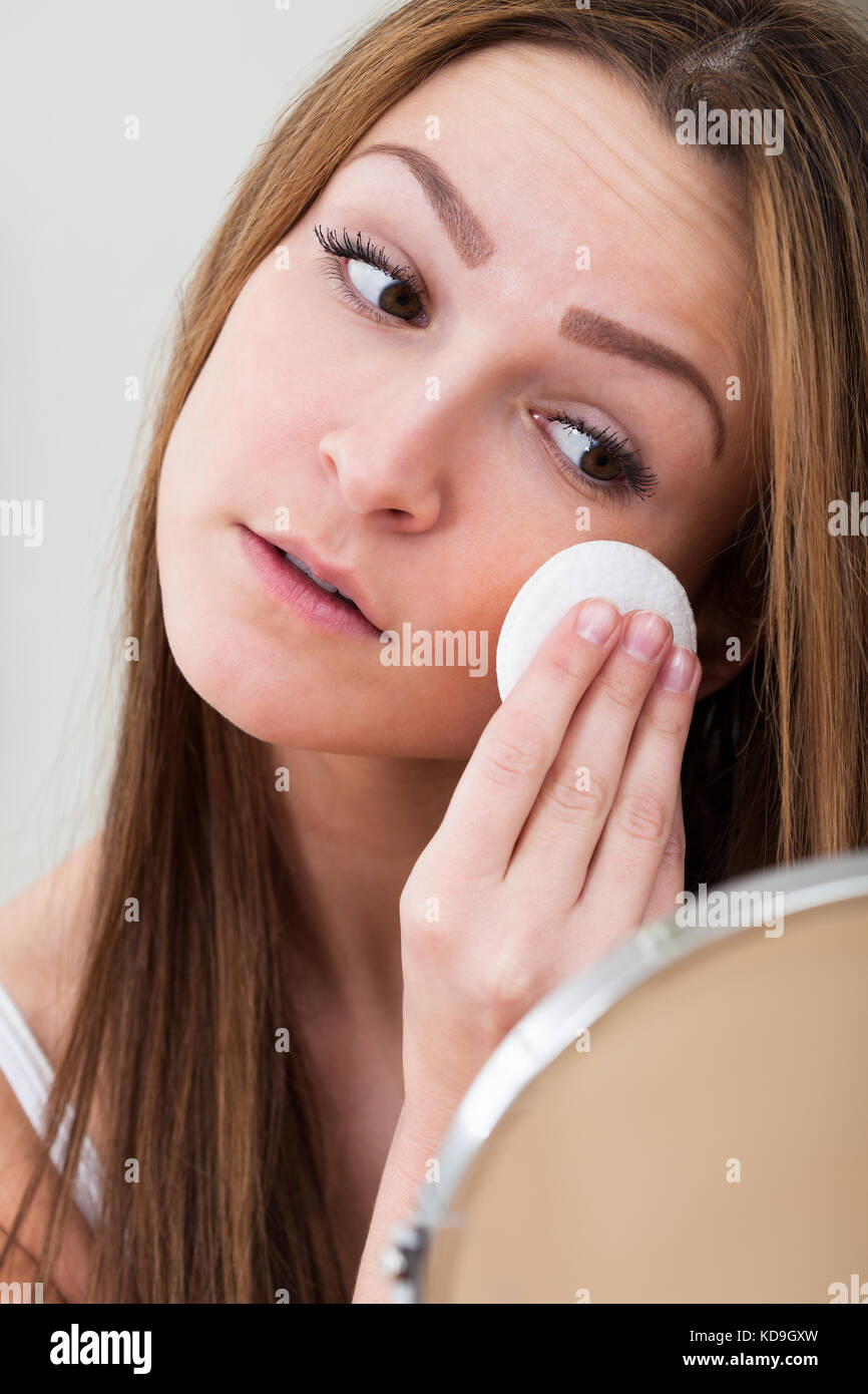 Portrait Of Young Woman Cleansing Her Face With Cotton Stock Photo