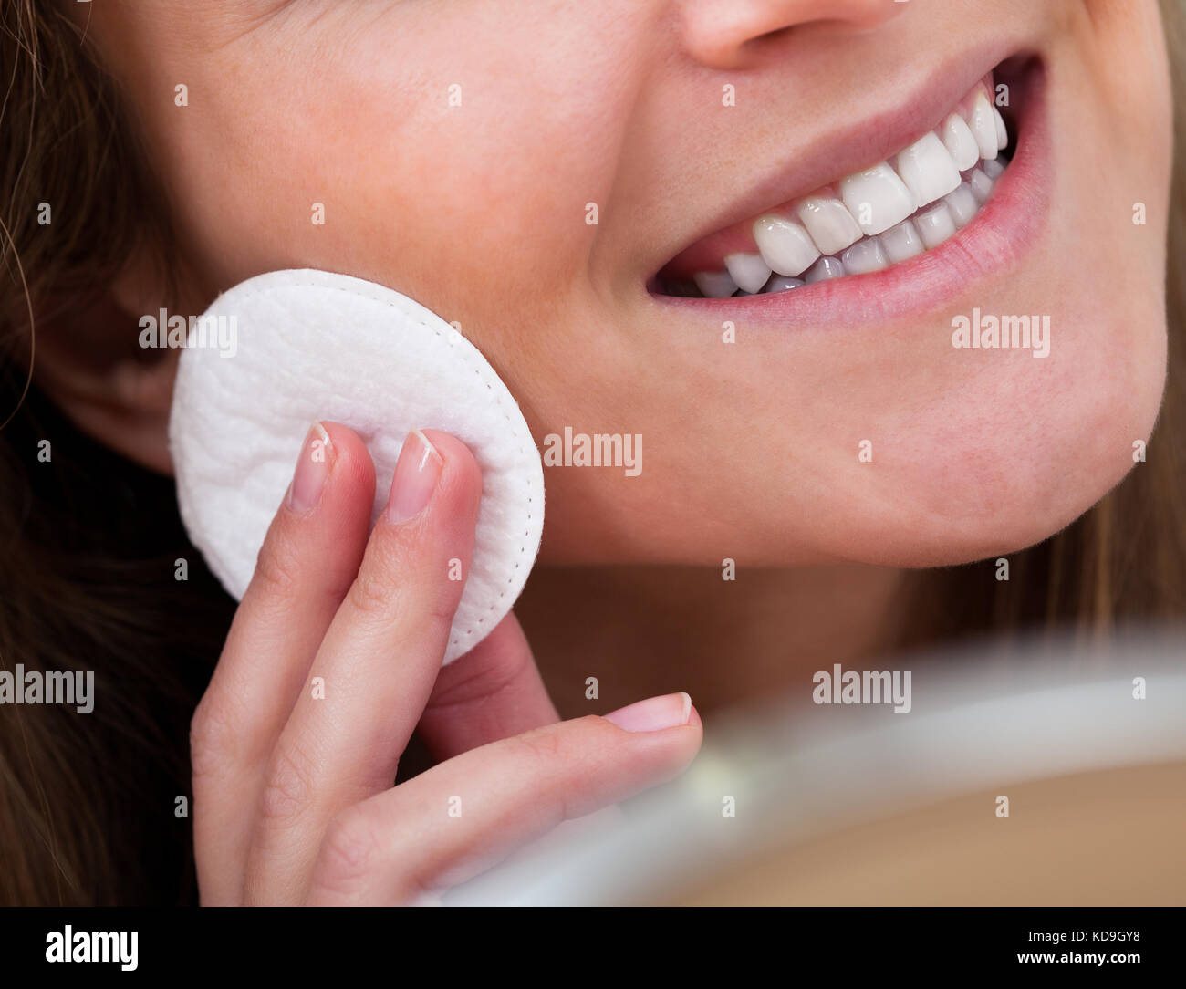 Portrait Of Young Woman Cleansing Her Face With Cotton Stock Photo