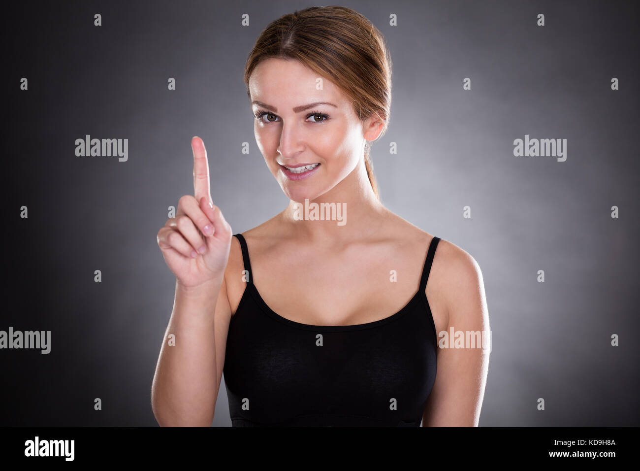 Fitness Woman Touching Screen Over Black Background Stock Photo