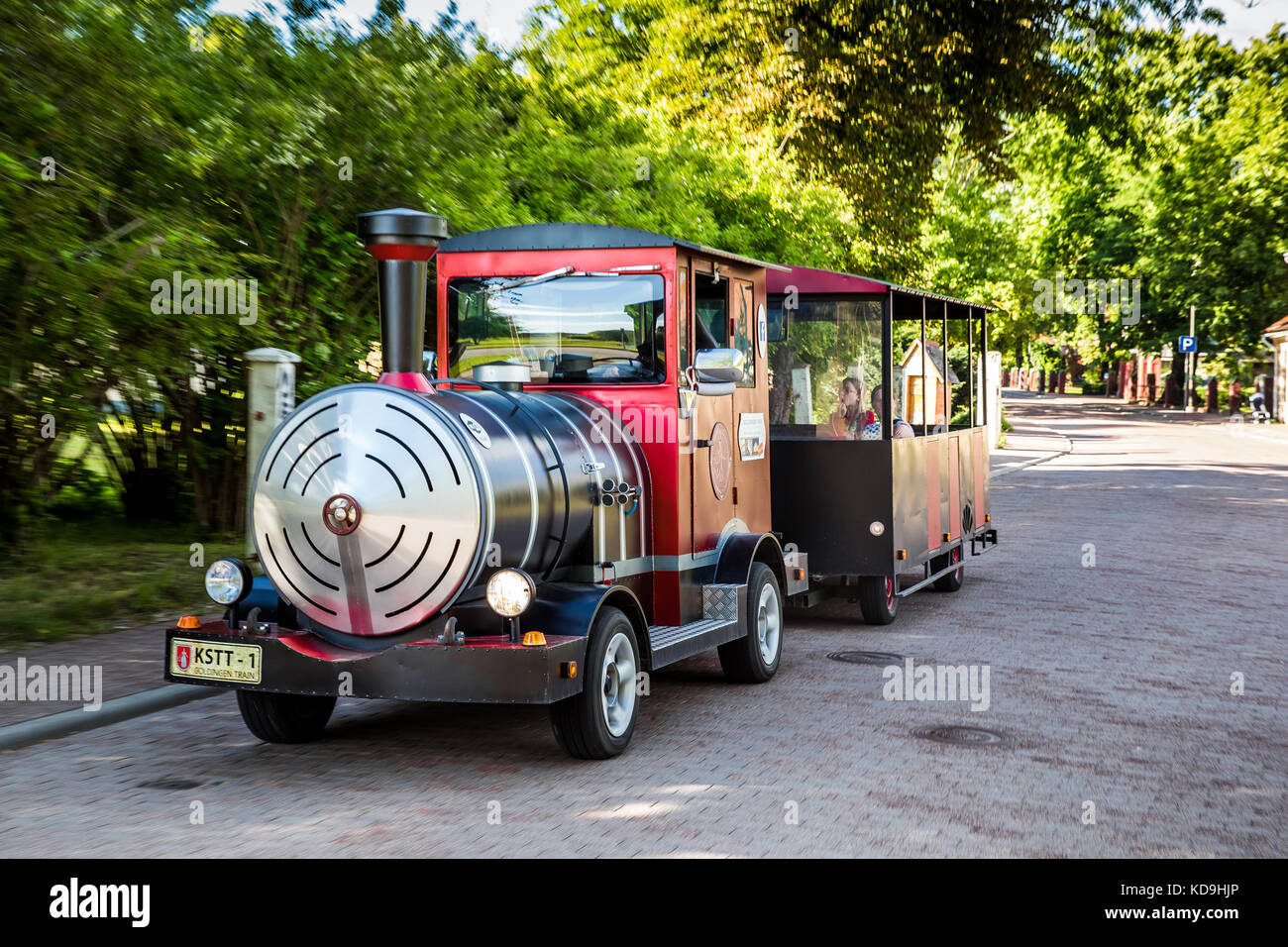 Small toursit train on the city street in Kuldiga, Latvia Stock Photo