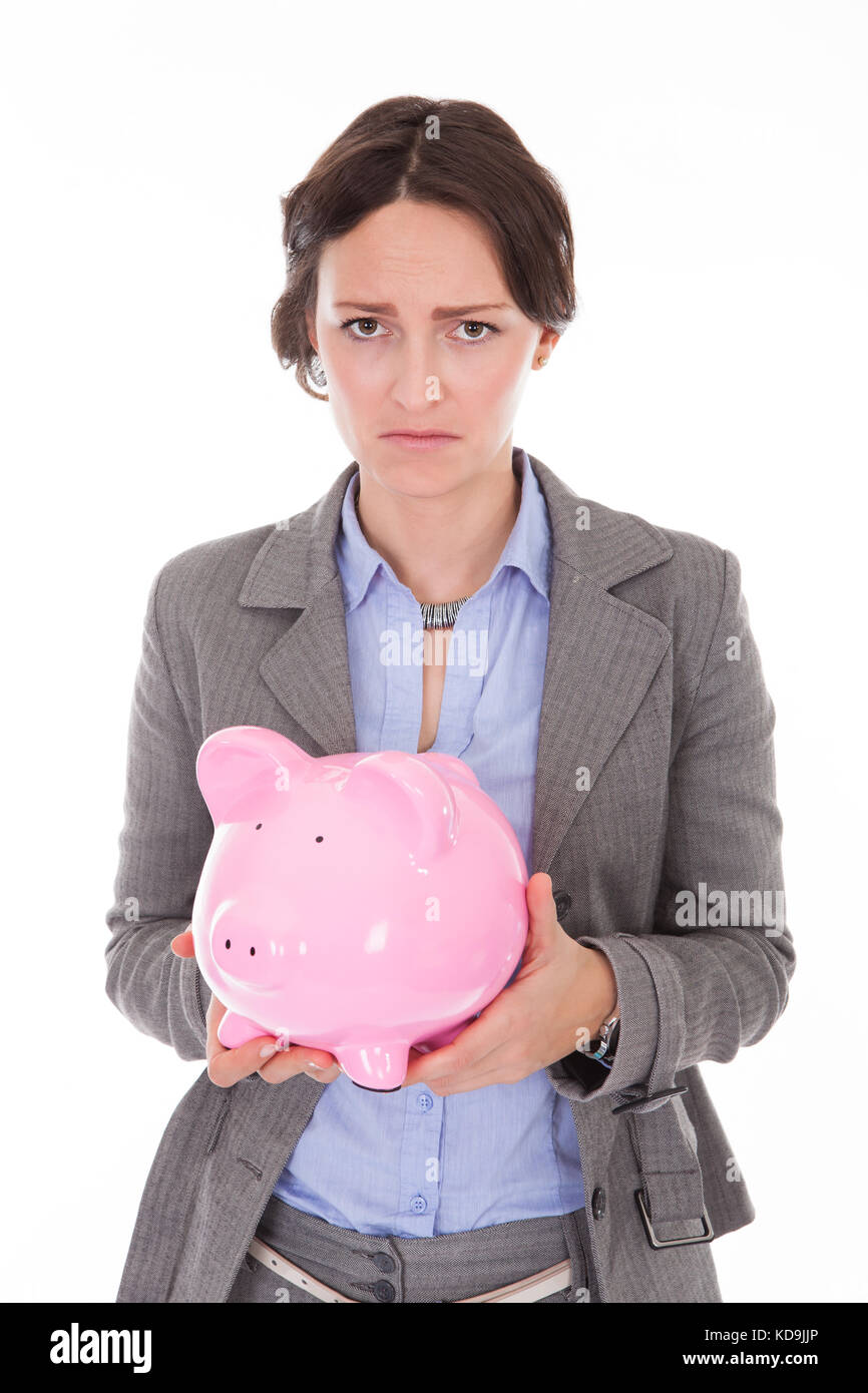 Displeased Young Businesswoman Holding Piggybank Over White Background Stock Photo