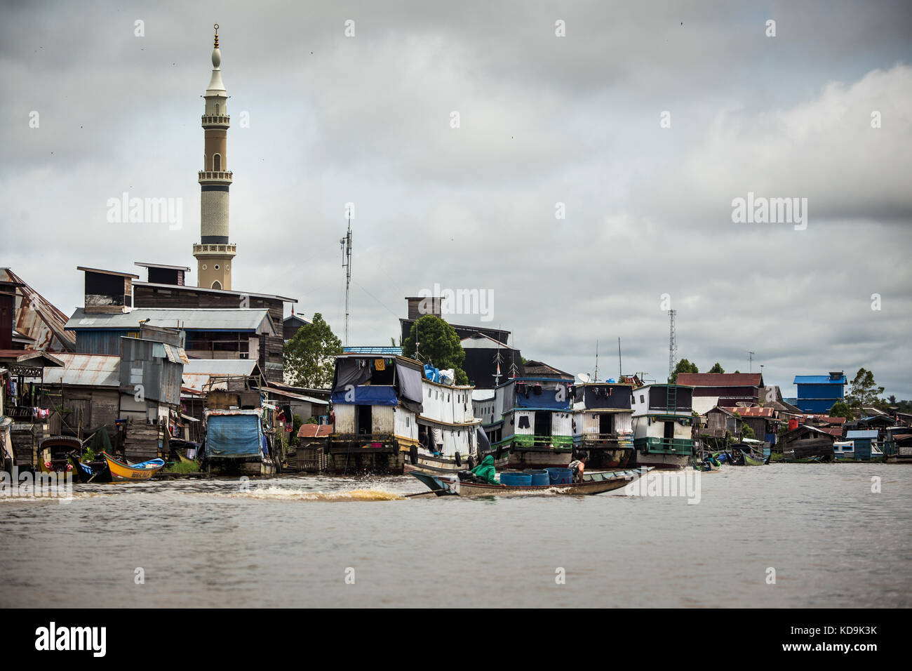 Unique boats beside the River Mahakam in Kalimantan. Borneo river transport. View from river at the third world structures, minaret and unusual boats Stock Photo