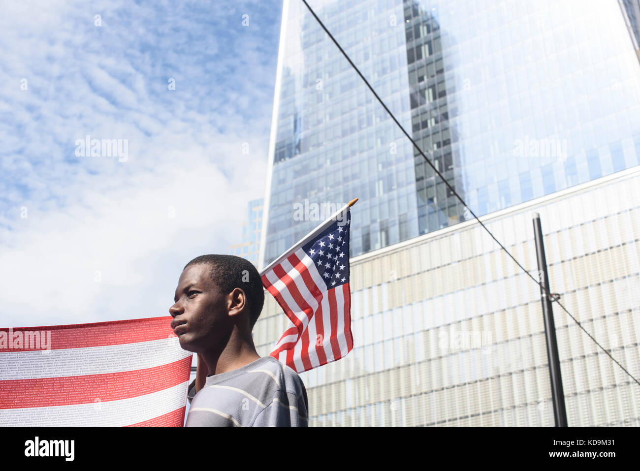 Un jeune américain tient un drapeau pour la commémoration des attentats du 9-11. Toutes les victimes seront écrites sur le drapeau. Le 16 septembre 20 Stock Photo