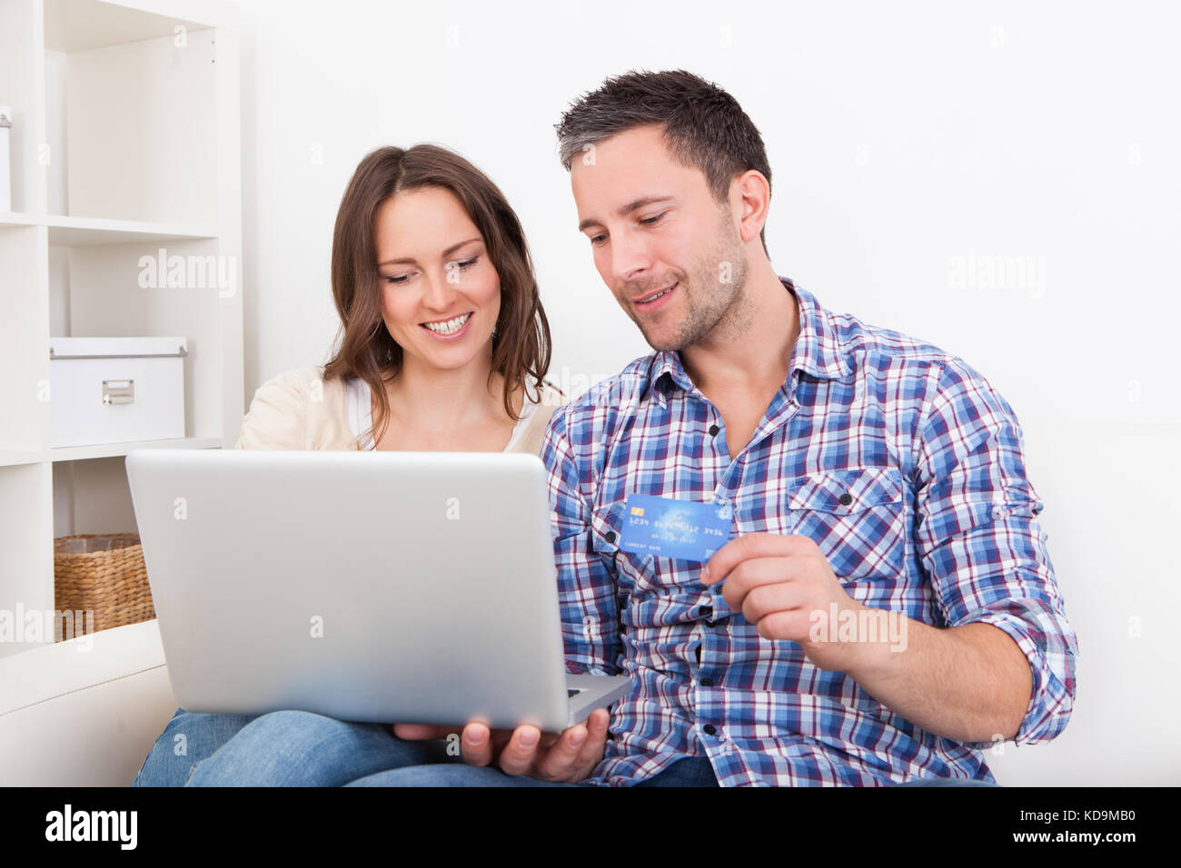 Portrait Of A Happy Young Couple Shopping Online With Credit Card Stock Photo