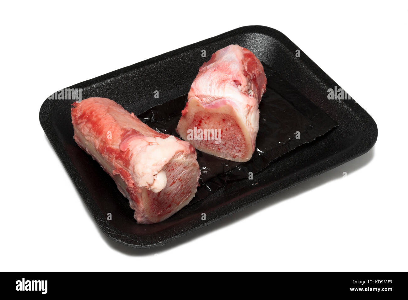 Marrow bones on butcher store black styrofoam container. White background. Horizontal. Stock Photo