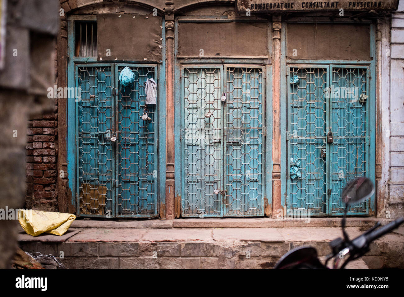 Three blue locked doors with iron gates and padlocks in New Delhi