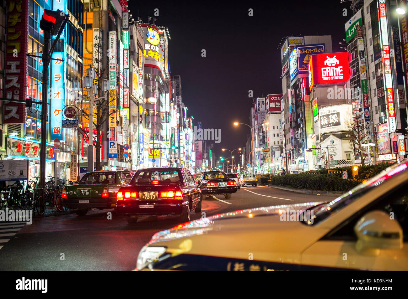 TOKYO - DECEMBER 31, 2016: Some taxi are passing in one of Japan's busiest crossroads in Shinjuko district at night. Shinjuku is a special ward in Tok Stock Photo