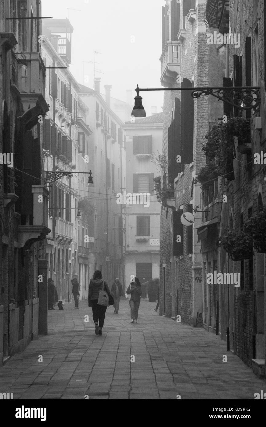 Venice, Italy. 11th October, 2017. (PICTURES HAS BEEN TAKEN IN BLACK AND WHITE)  Citizen walk in a street during a foggy morning in Venice, Italy. In this period in Venice starts the first foggy mornings. © Simone Padovani / Awakening / Alamy Live News Stock Photo