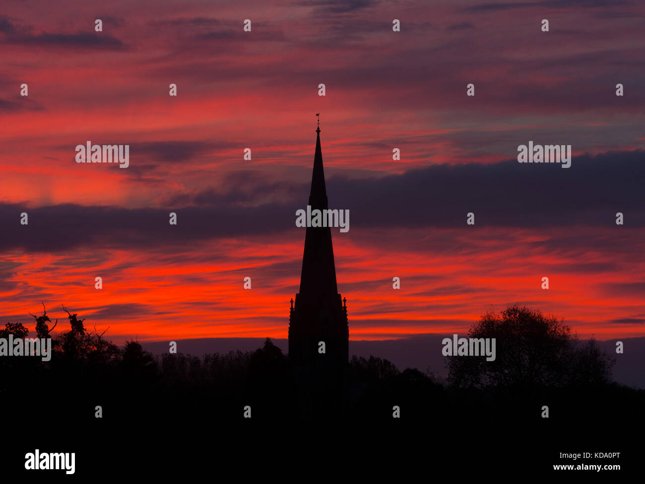 Sherbourne, Warwickshire, UK. 12th Oct, 2017. UK Weather. A spectacular dawn sky forms a backdrop to the spire of All Saints Church at Sherbourne, a village in Warwickshire. The Victorian Gothic church was designed by the eminent architect Sir George Gilbert Scott. Credit: Colin Underhill/Alamy Live News Stock Photo