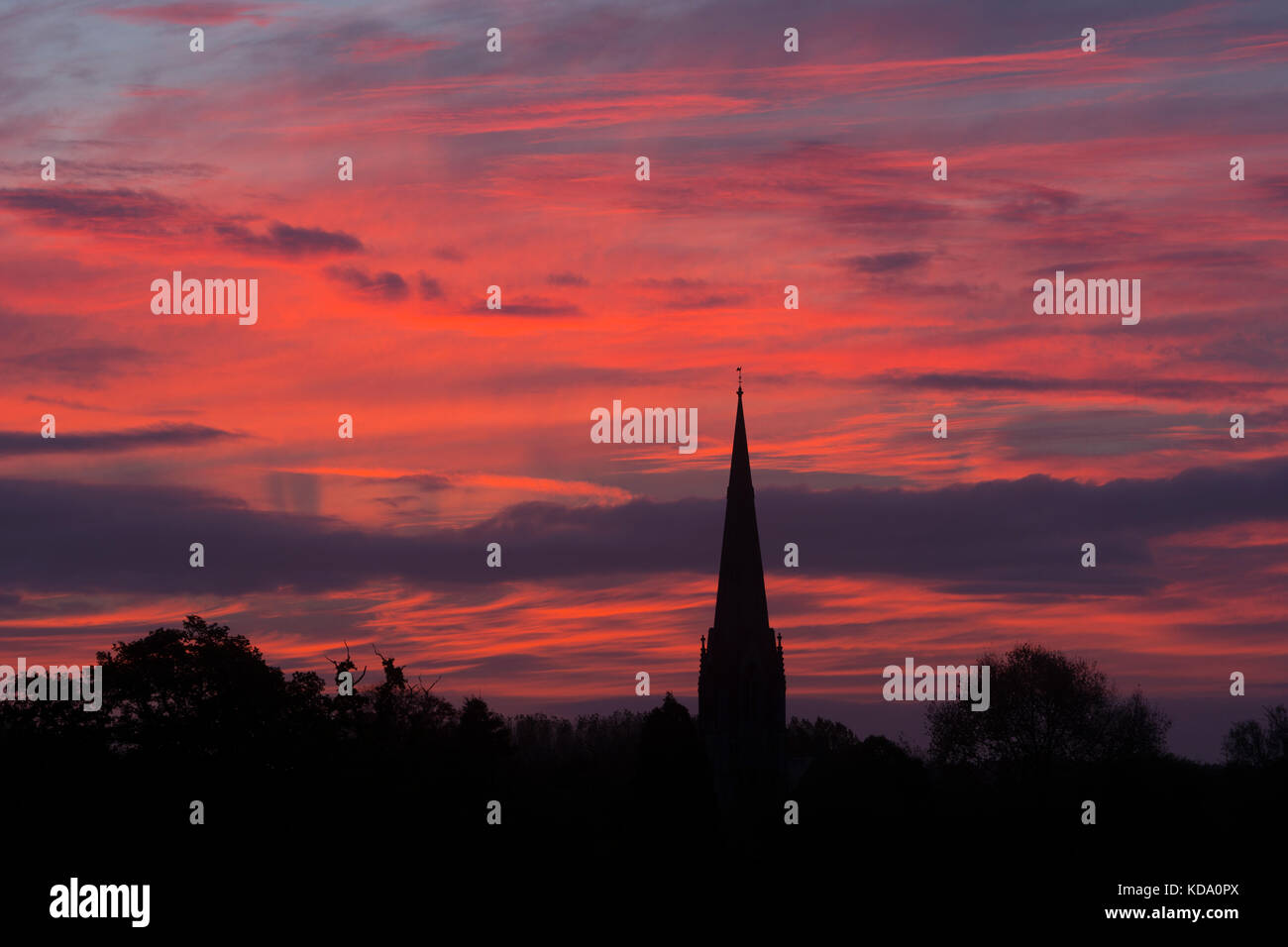 Sherbourne, Warwickshire, UK. 12th Oct, 2017. UK Weather. A spectacular dawn sky forms a backdrop to the spire of All Saints Church at Sherbourne, a village in Warwickshire. The Victorian Gothic church was designed by the eminent architect Sir George Gilbert Scott. Credit: Colin Underhill/Alamy Live News Stock Photo
