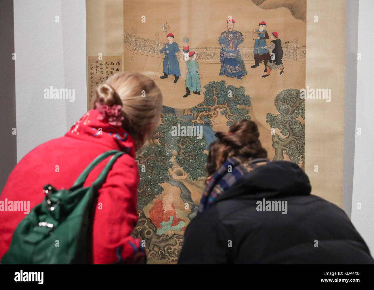 Berlin, Germany. 11th Oct, 2017. Two visitors look on a painting during the Chinese portrait painting exhibition 'Faces of China, Portrait Painting of the Ming and Qing Dynasties (1368-1912)' in Berlin, capital of Germany, on Oct. 11, 2017. Europe's first-ever grand exhibition explicitly dedicated to Chinese portrait paintings was unveiled in Berlin in the evening of Wednesday, the day China and Germany celebrated the 45th anniversary of the establishment of diplomatic ties. Credit: Shan Yuqi/Xinhua/Alamy Live News Stock Photo