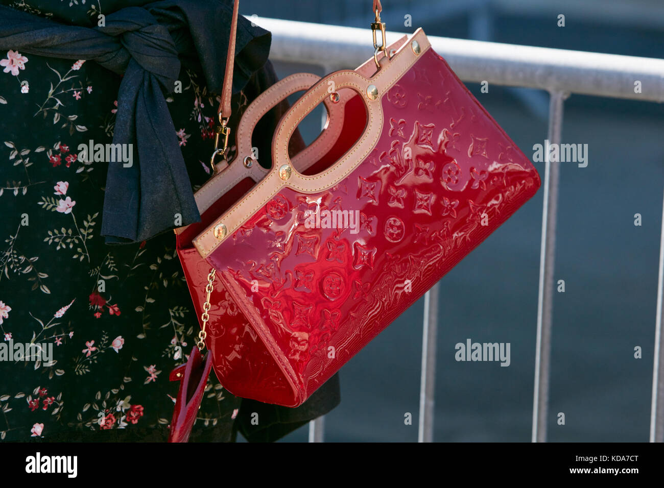 MILAN - SEPTEMBER 20: Woman with red shiny Louis Vuitton bag and