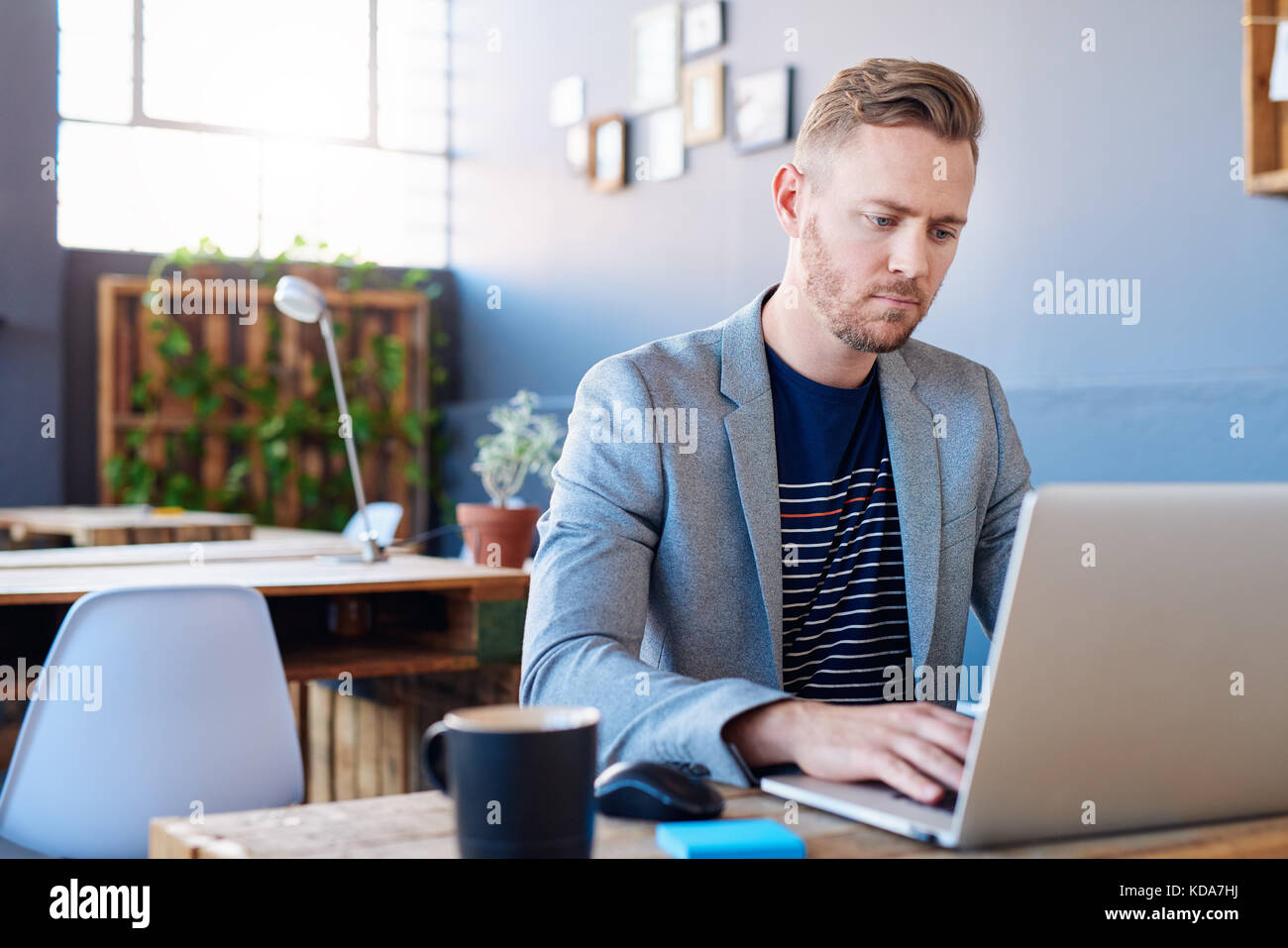 Focused young businessman working on a laptop in an office Stock Photo