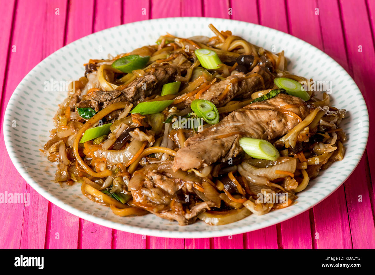 Chinese Style Hoisin Duck Noodles with Pak Choi Against a Pink Wooden
