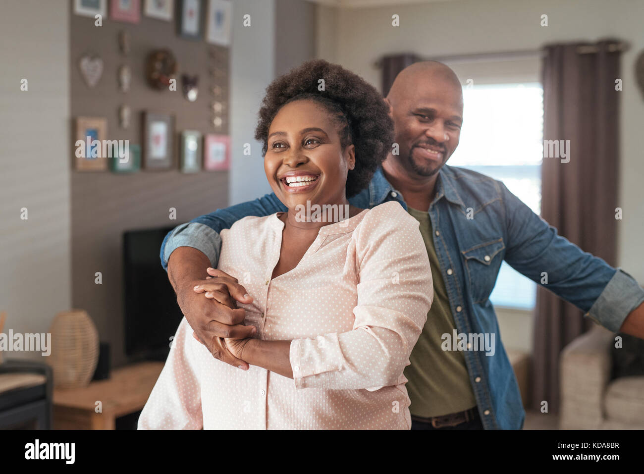 Laughing African couple enjoying a playful moment together at home Stock Photo