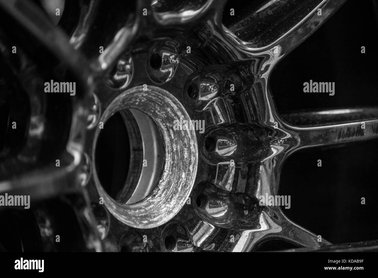 Racing car wheel rim bolt extrem closeup, steel object black and white selective focus Stock Photo