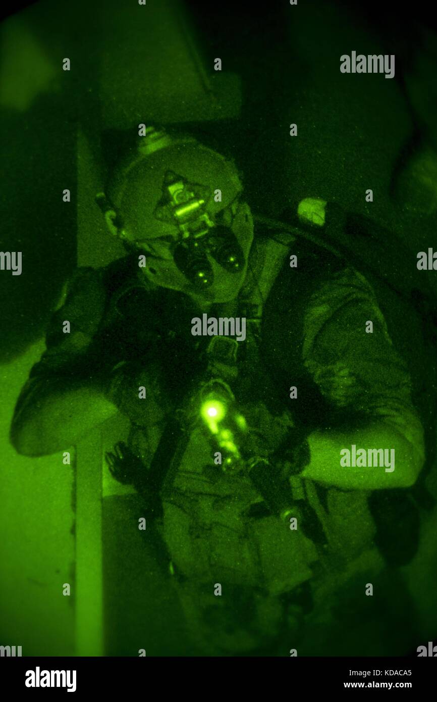 A U.S. Marine Corps soldier provides security through night vision goggles during visit, board, search and seizure training for the Company Collective Exercise at the Marine Corps Base Camp Pendleton October 15, 2015 in San Diego, California. Stock Photo