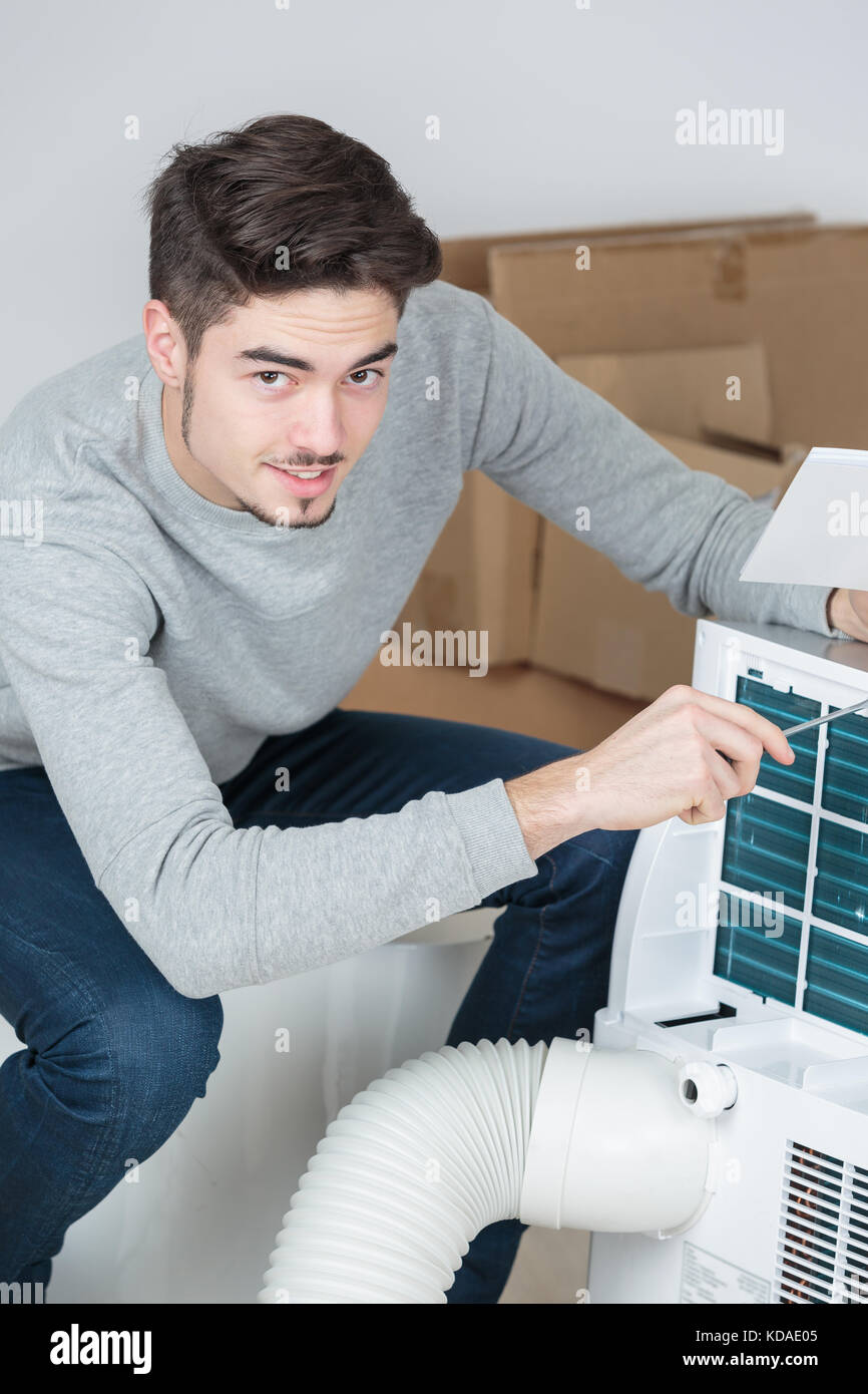 Young mn woking on air conditioning unit Stock Photo Alamy
