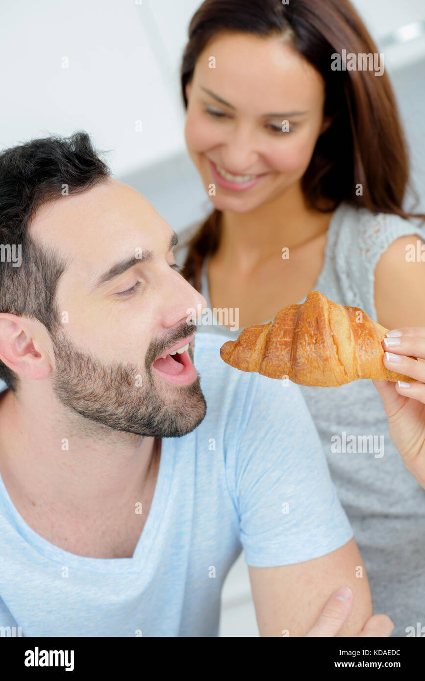 View of Romantic couple sharing a croissant Stock Photo - Alamy