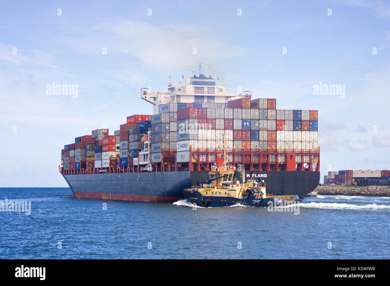 Container ship in Swan River departing Fremantle port with assistance of tugboat Stock Photo