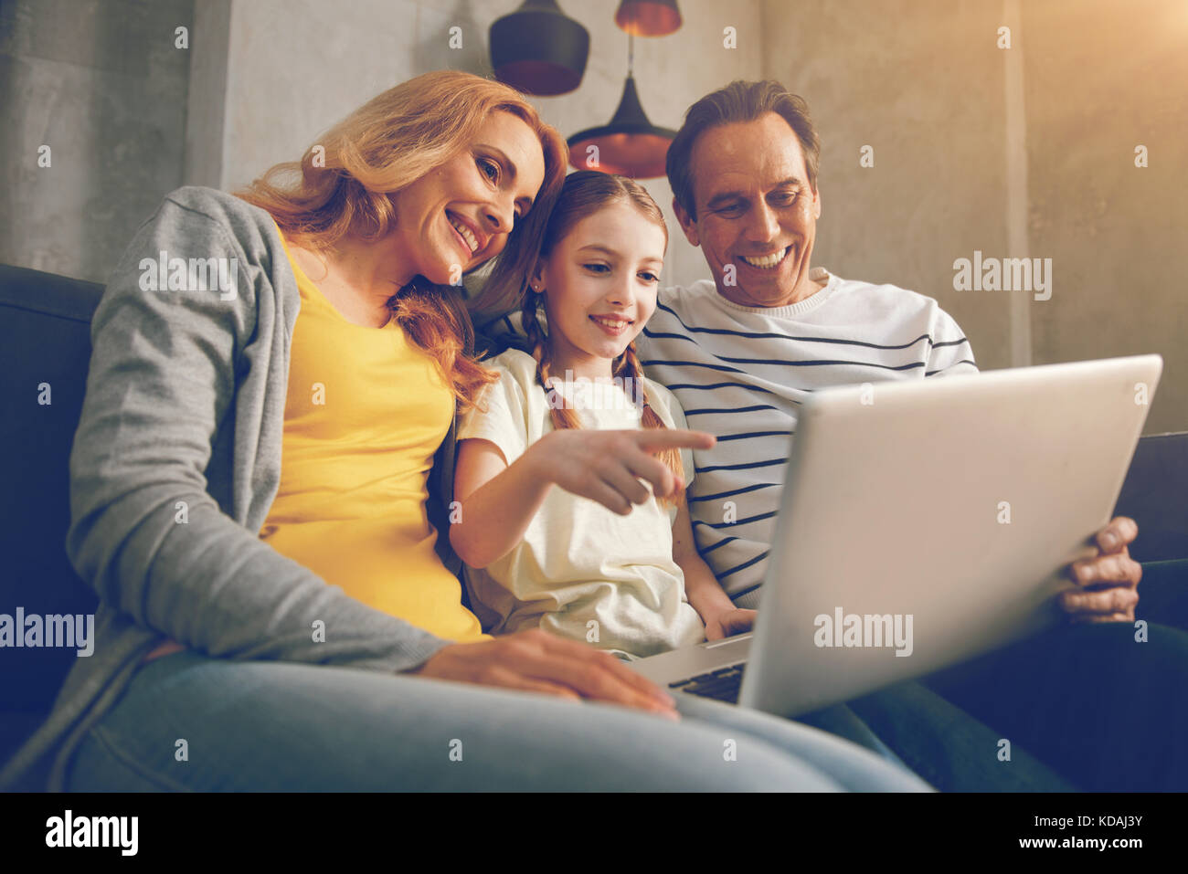 Happy family using laptop together Stock Photo - Alamy