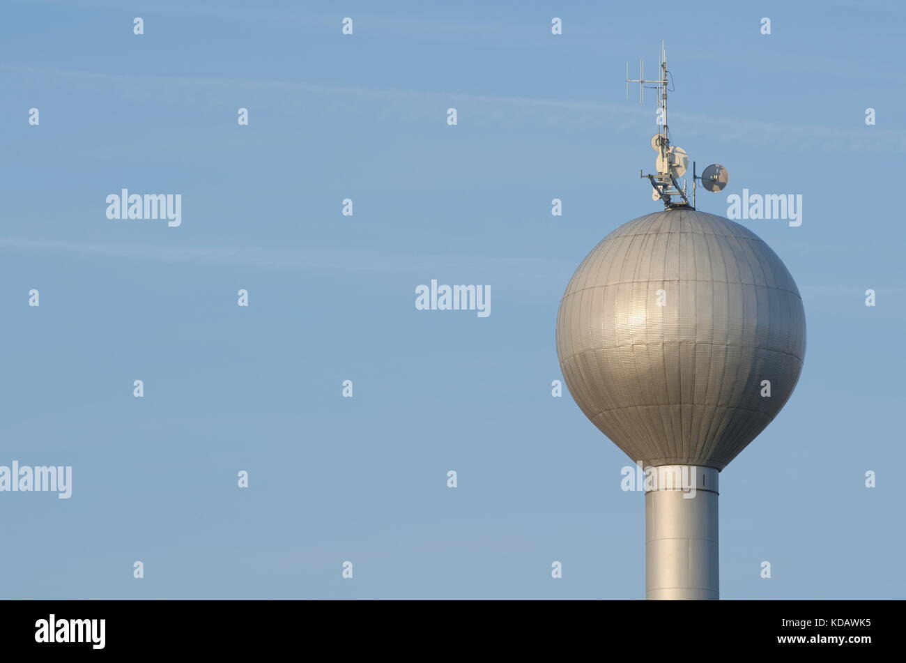 Bright Water Tower with Antenna Under Blue Sky Closeup Stock Photo