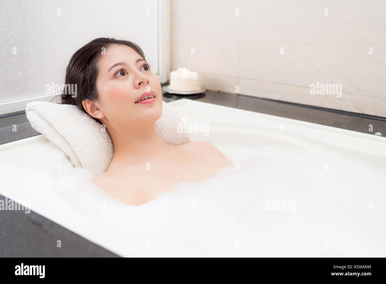 smiling beautiful woman lying down in bathtub relaxing thinking future